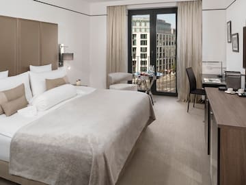 a bedroom with a bed and a table and chairs