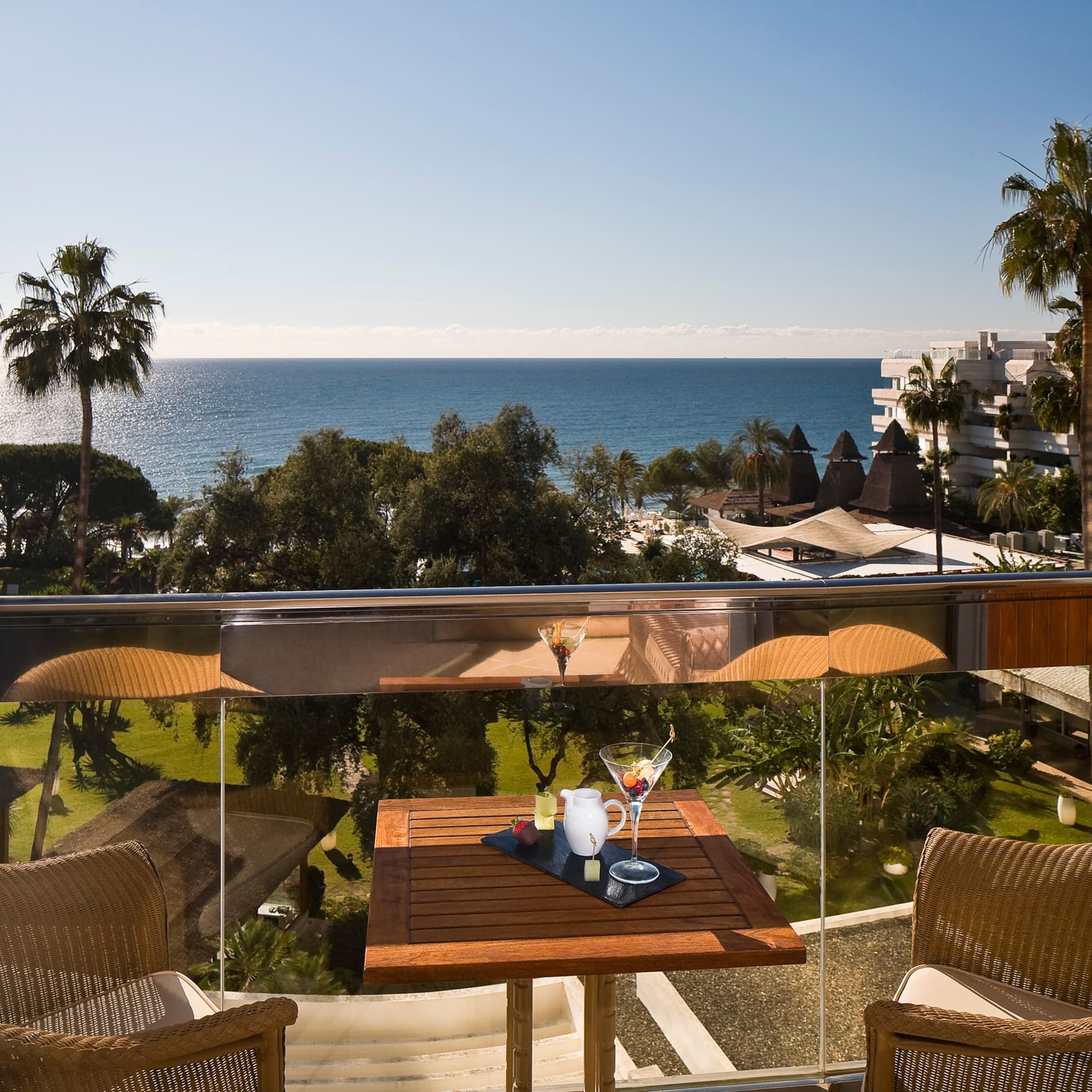 a table and chairs on a balcony overlooking a body of water
