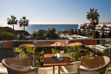 a table and chairs on a balcony overlooking a body of water