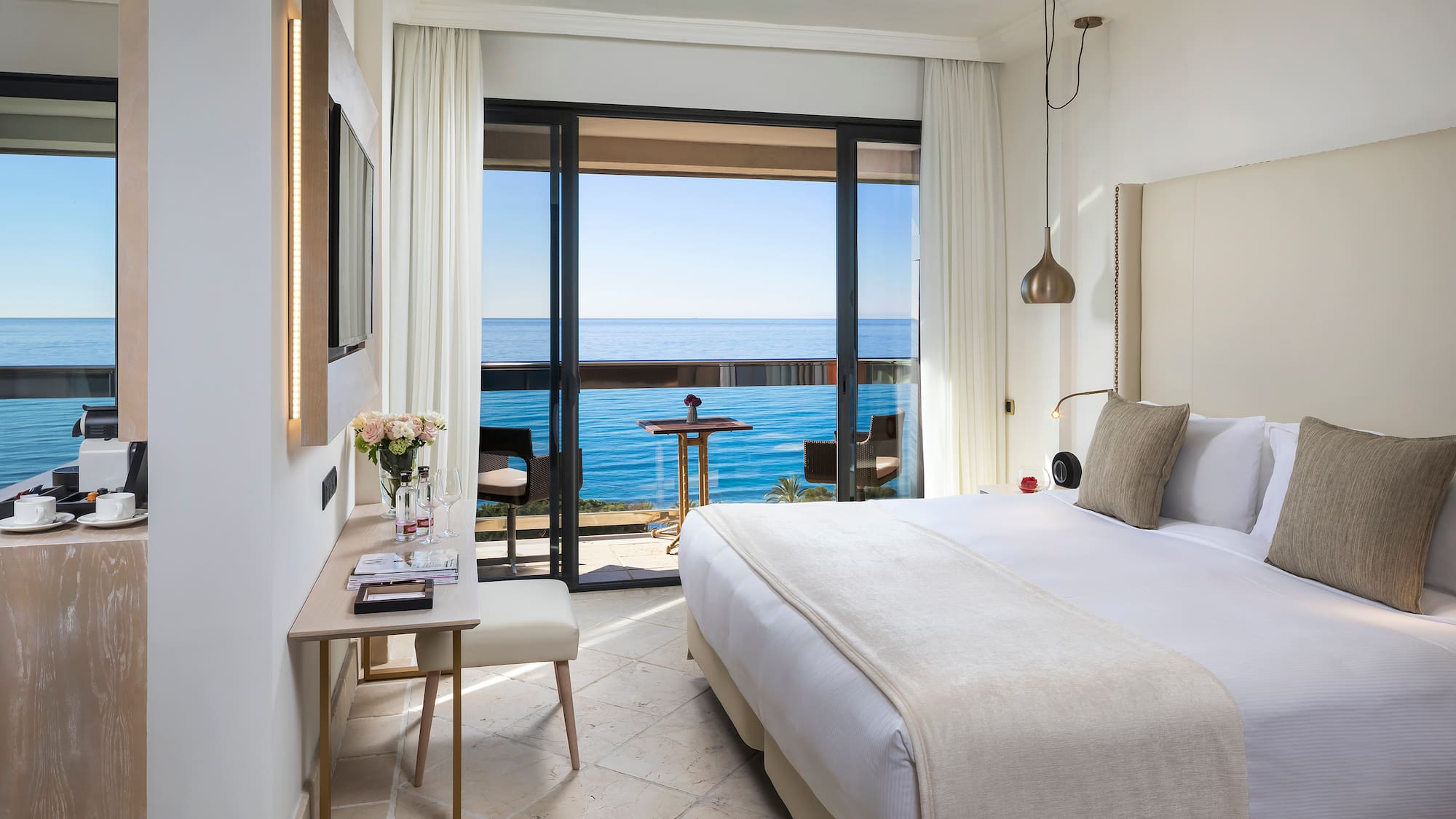 a bedroom with a large window overlooking the ocean