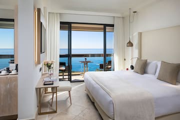 a bedroom with a large window overlooking the ocean