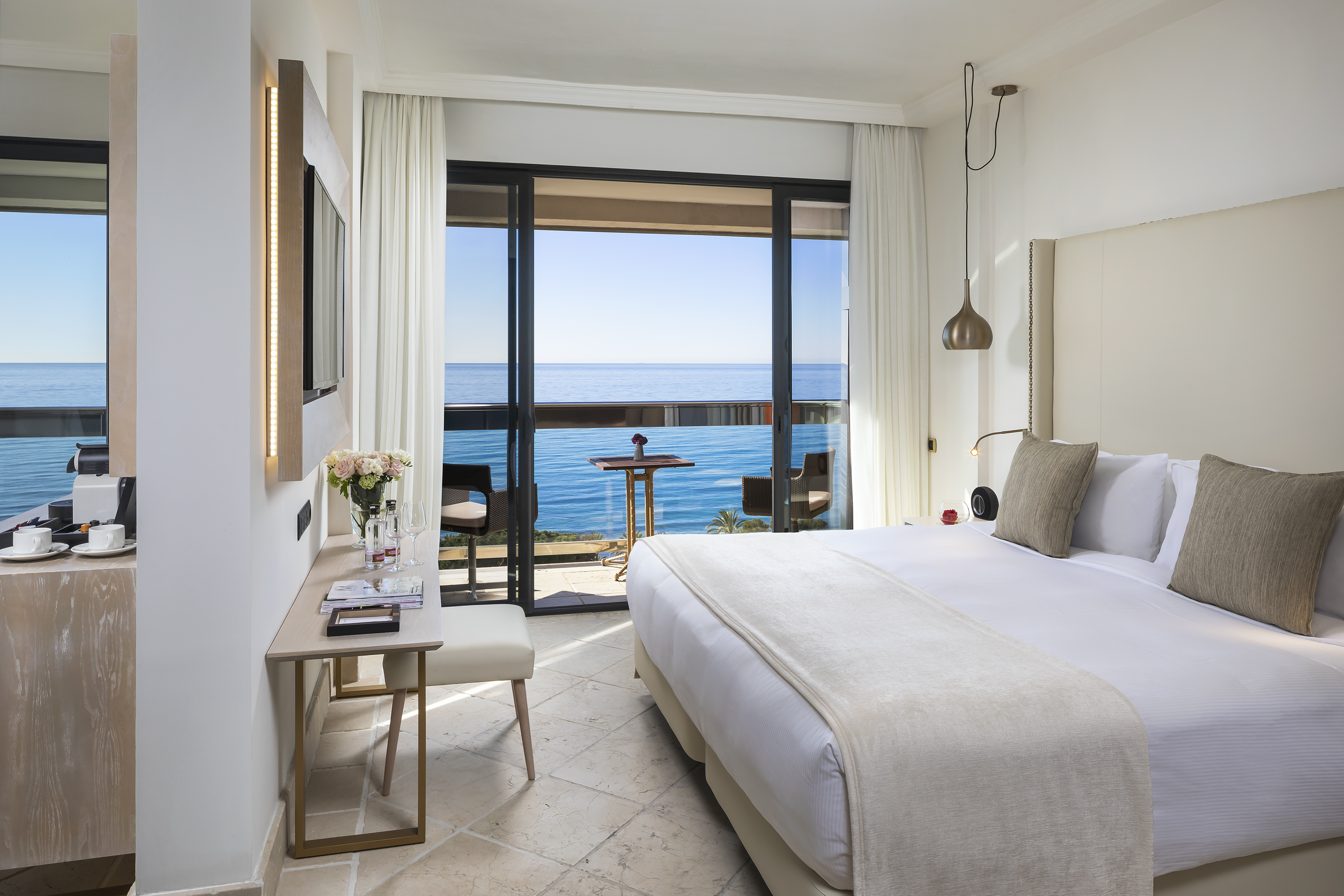 a bedroom with a large window overlooking the ocean