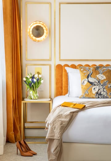 a bed with a vase of flowers on it