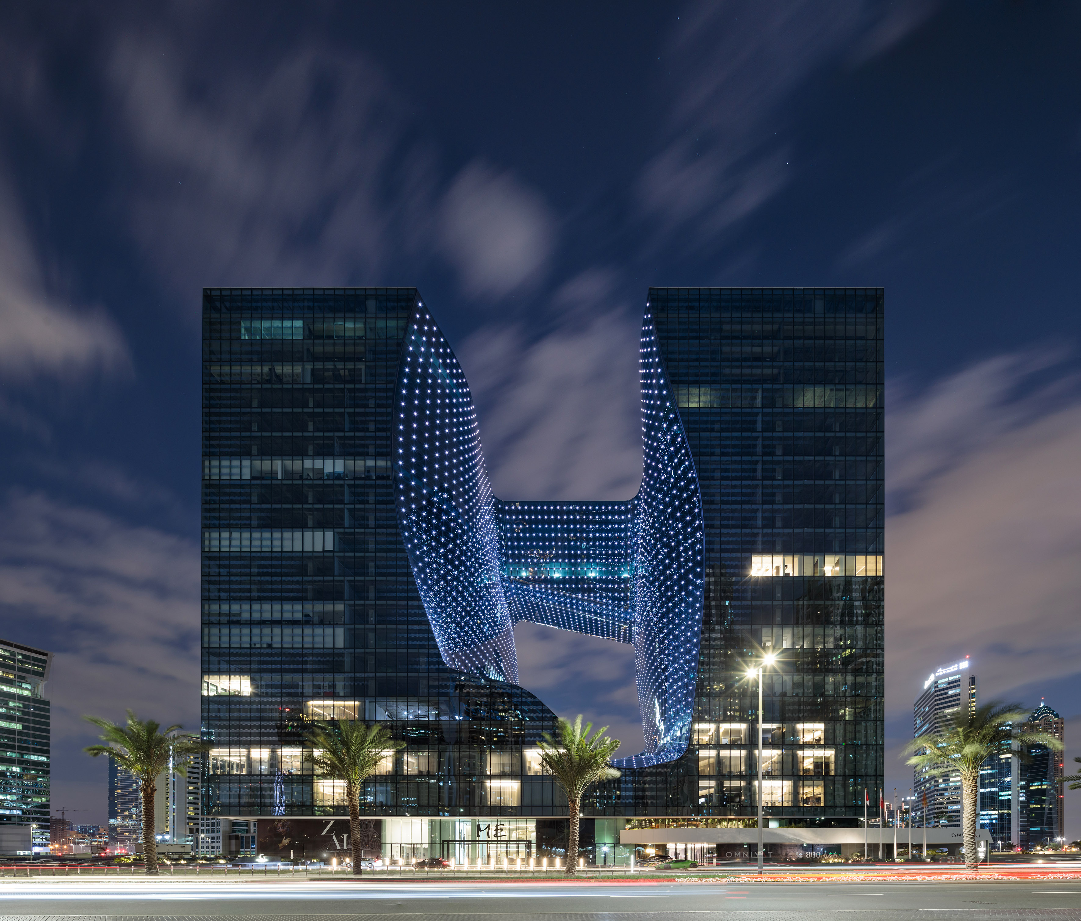 Zaha Hadid Opus building in Dubai, illuminated void at night.