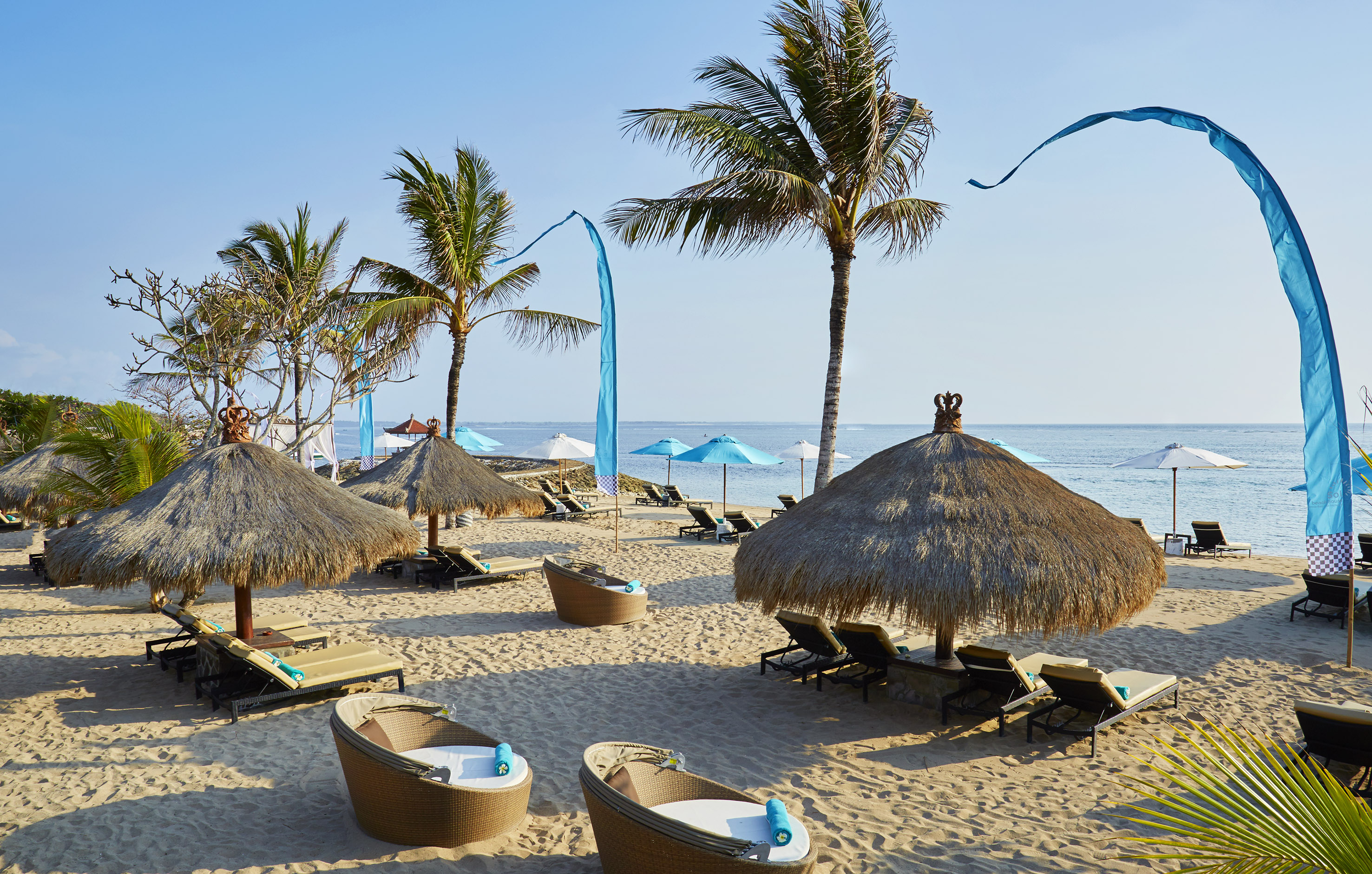 a beach with palm trees and chairs