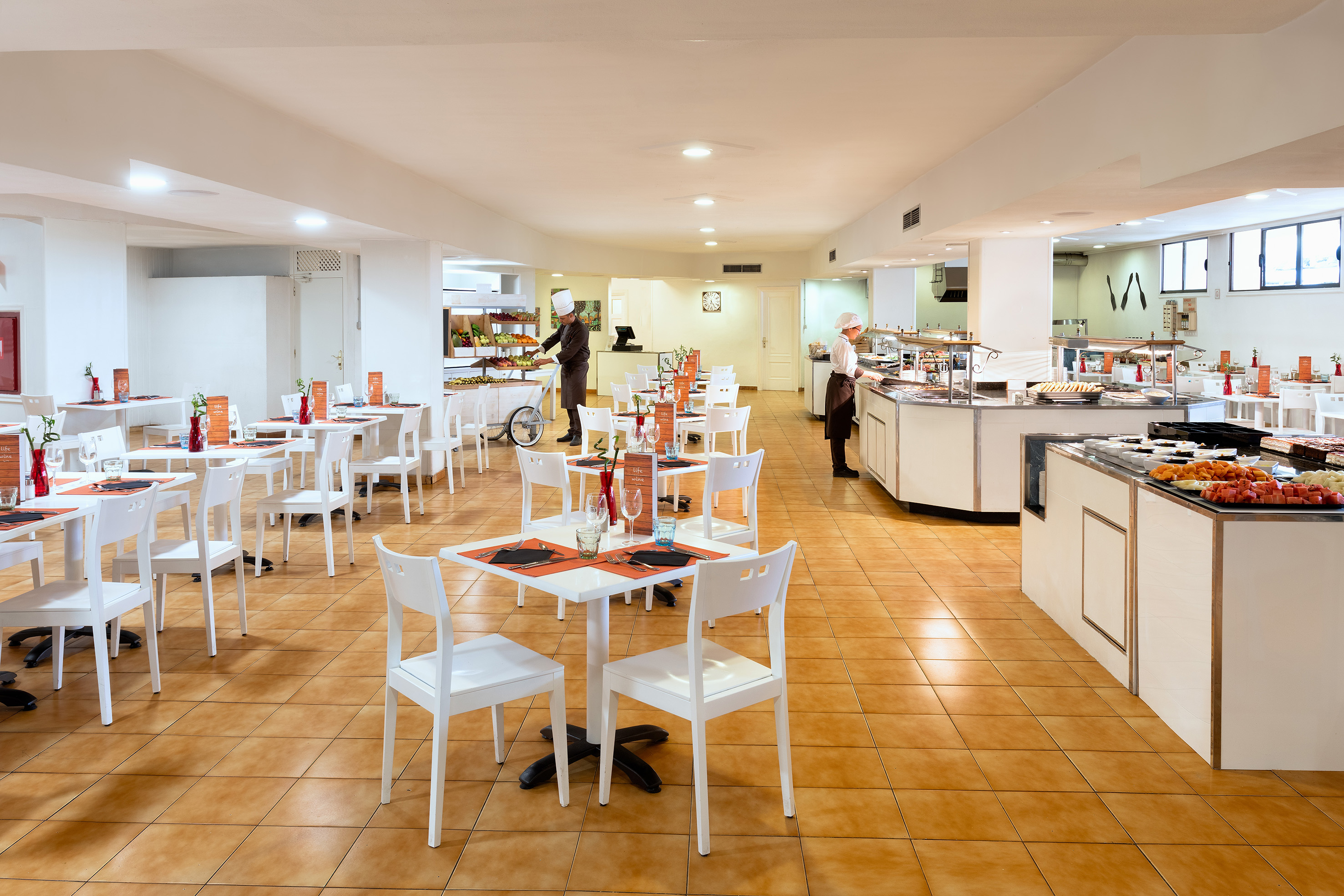 Bright hotel buffet restaurant with food stations and chefs.