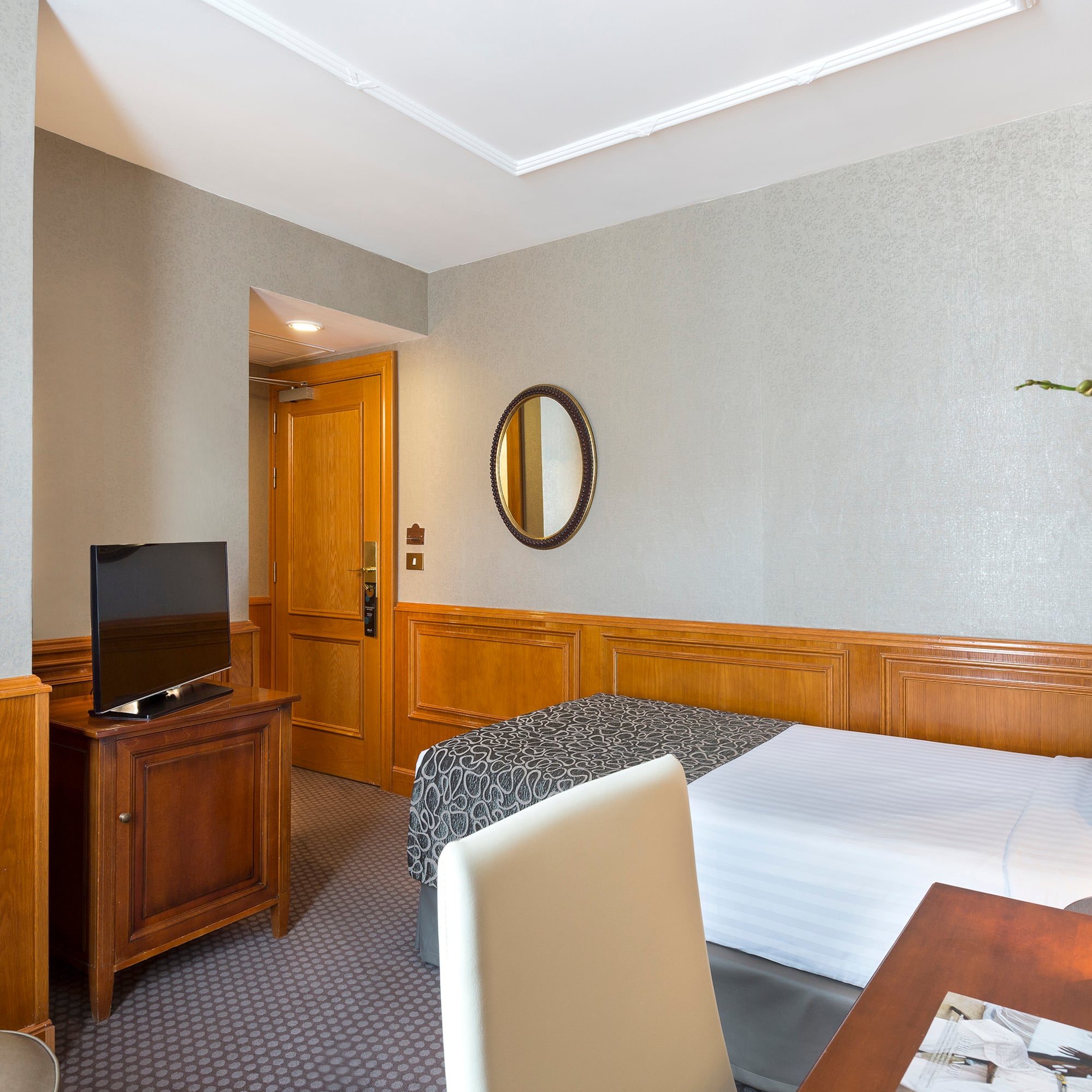 a room with a bed and a table and a mirror