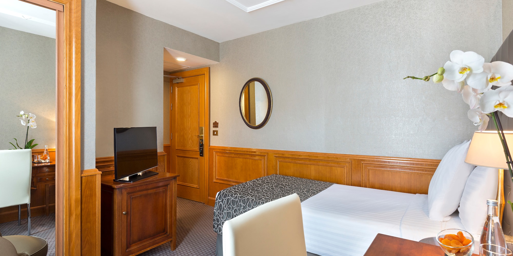 a room with a bed and a table and a mirror