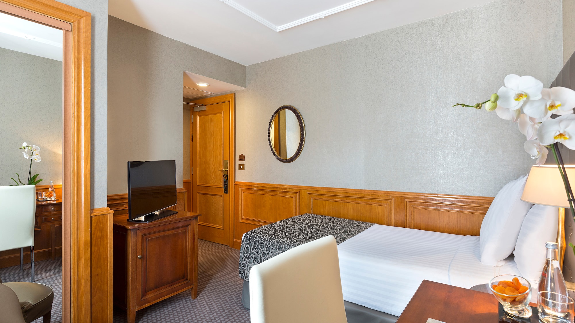 a room with a bed and a table and a mirror