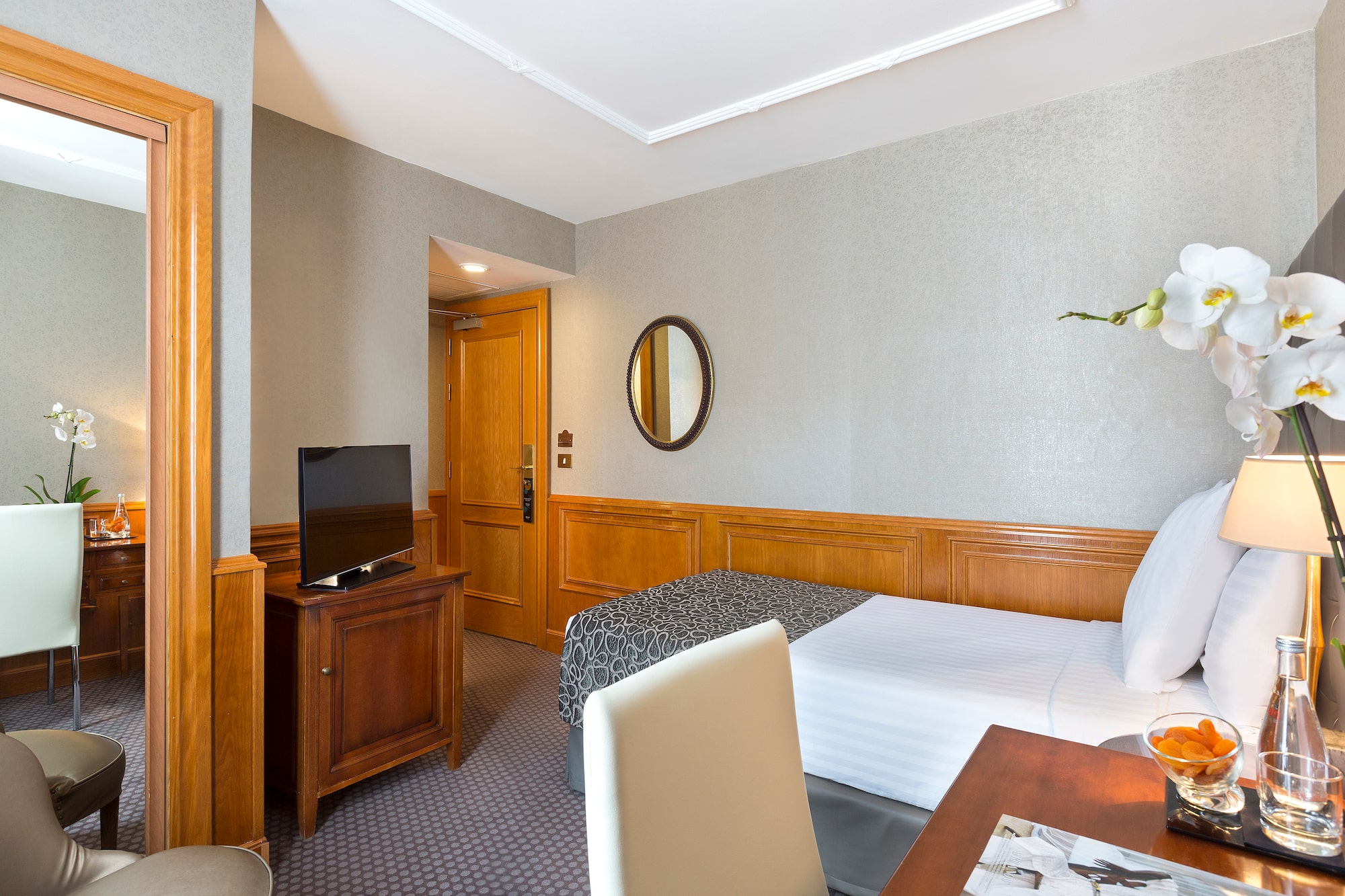 a room with a bed and a table and a mirror