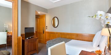 a room with a bed and a table and a mirror