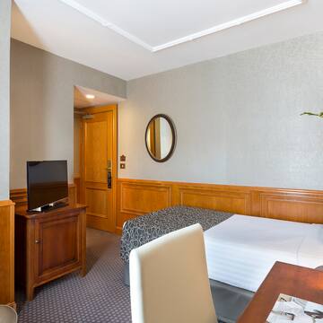 a room with a bed and a table and a mirror