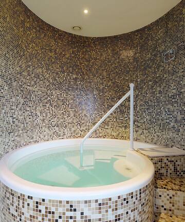 a jacuzzi with a white tub in a tiled room