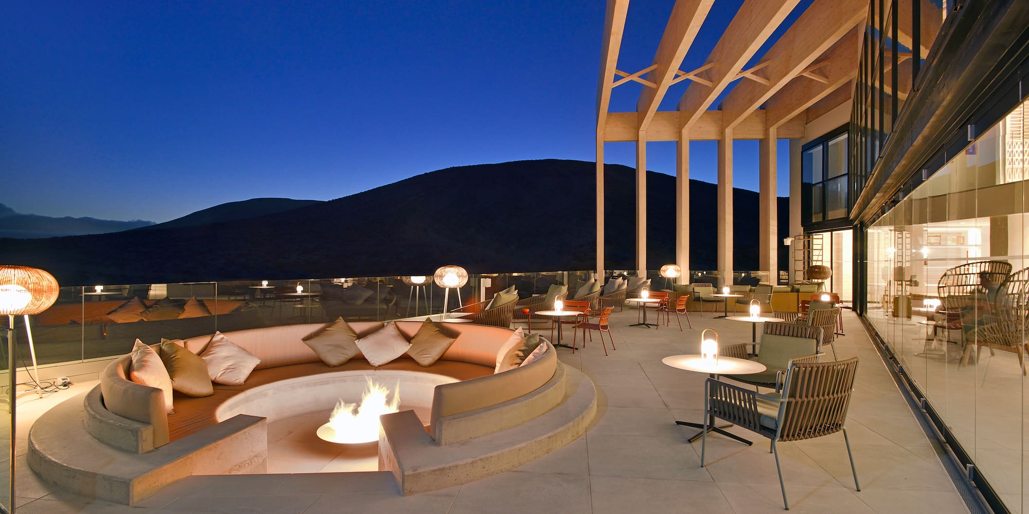 a patio with a fire pit and chairs