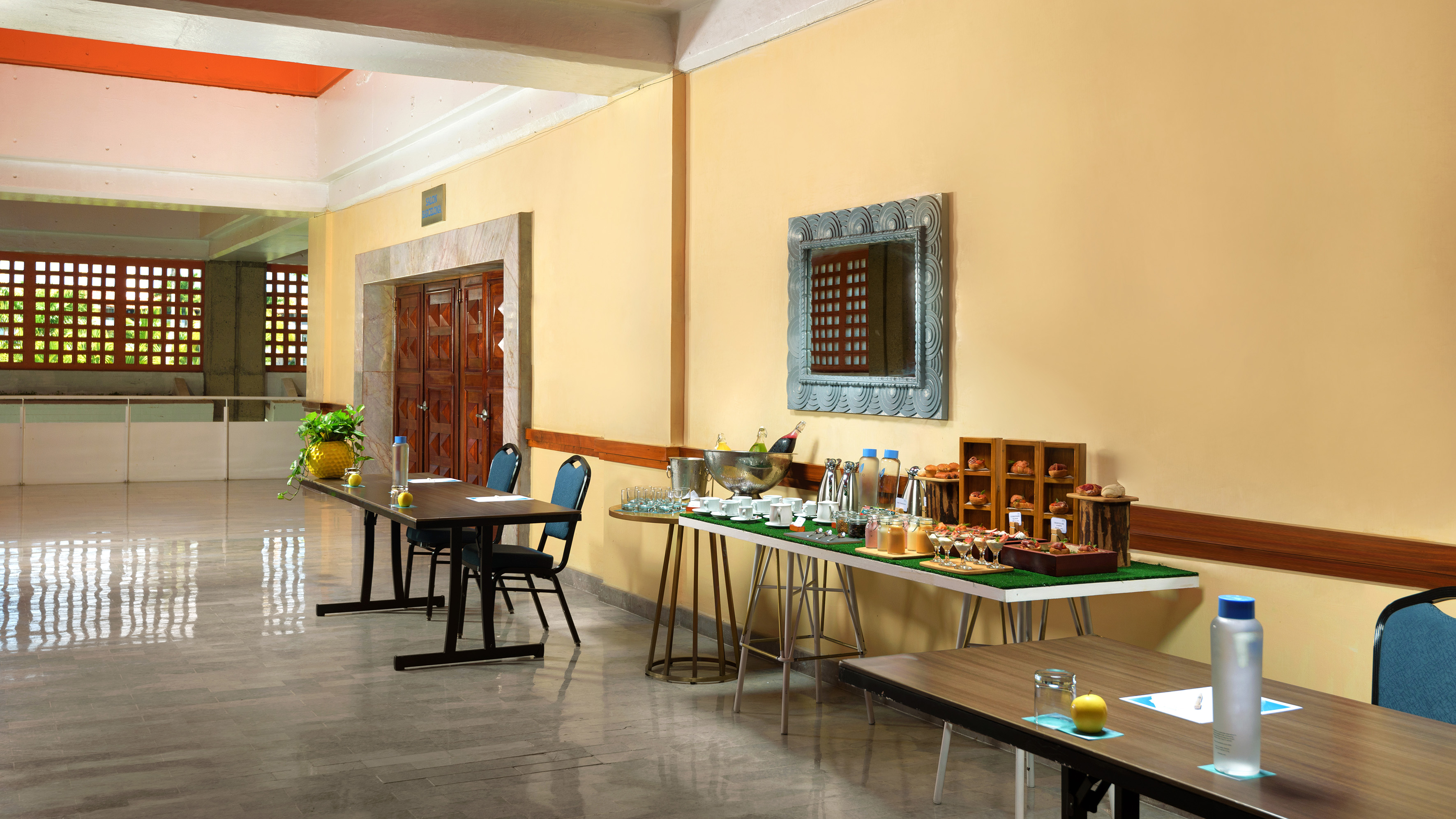 Hotel meeting space with refreshment buffet of drinks, pastries, and long tables.