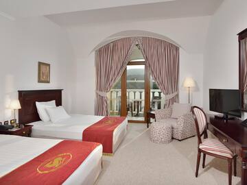a room with two beds and a television