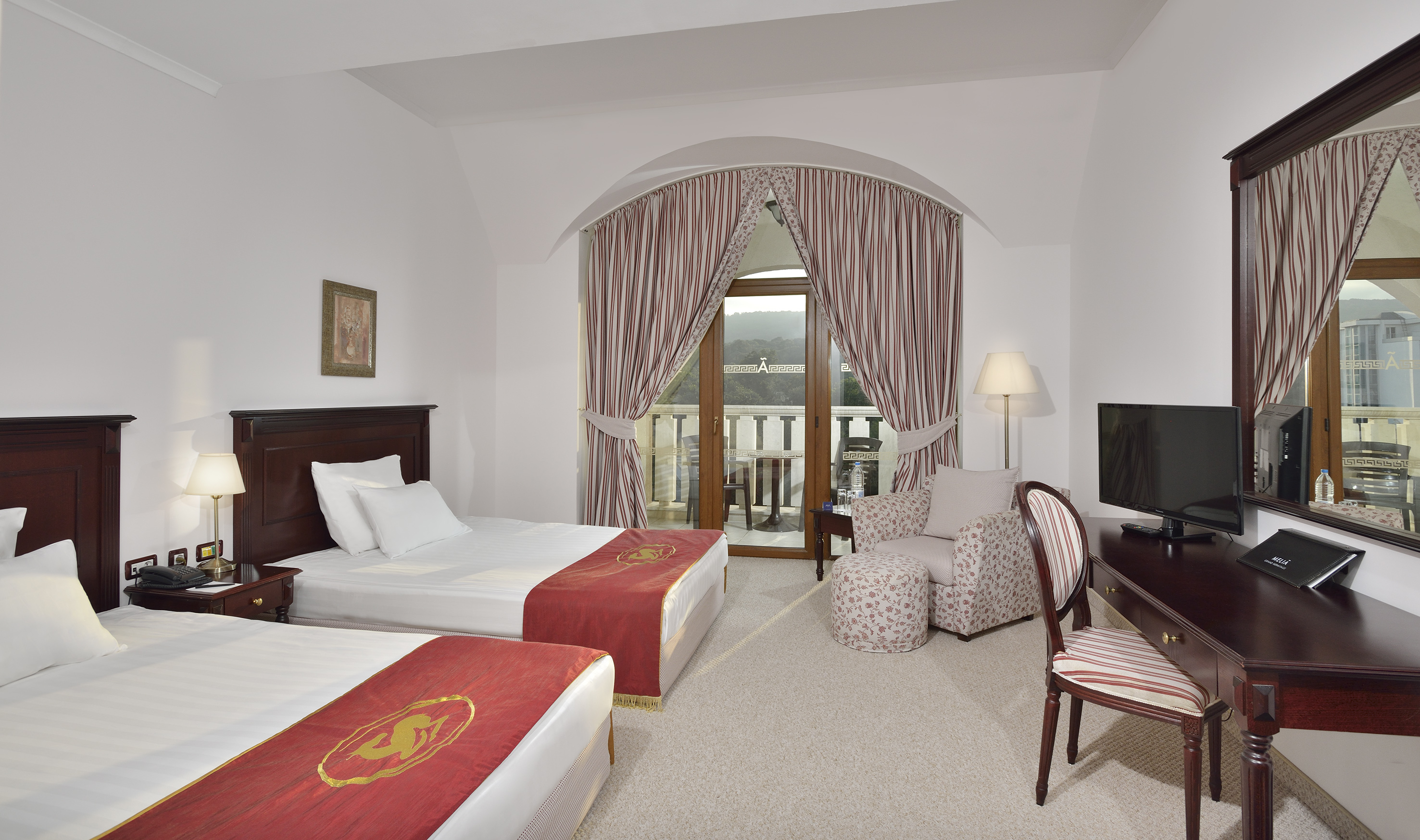a room with two beds and a television - Classic Room Twin Beds și Vedere la Parc - Meliá Grand Hermitage, Varna