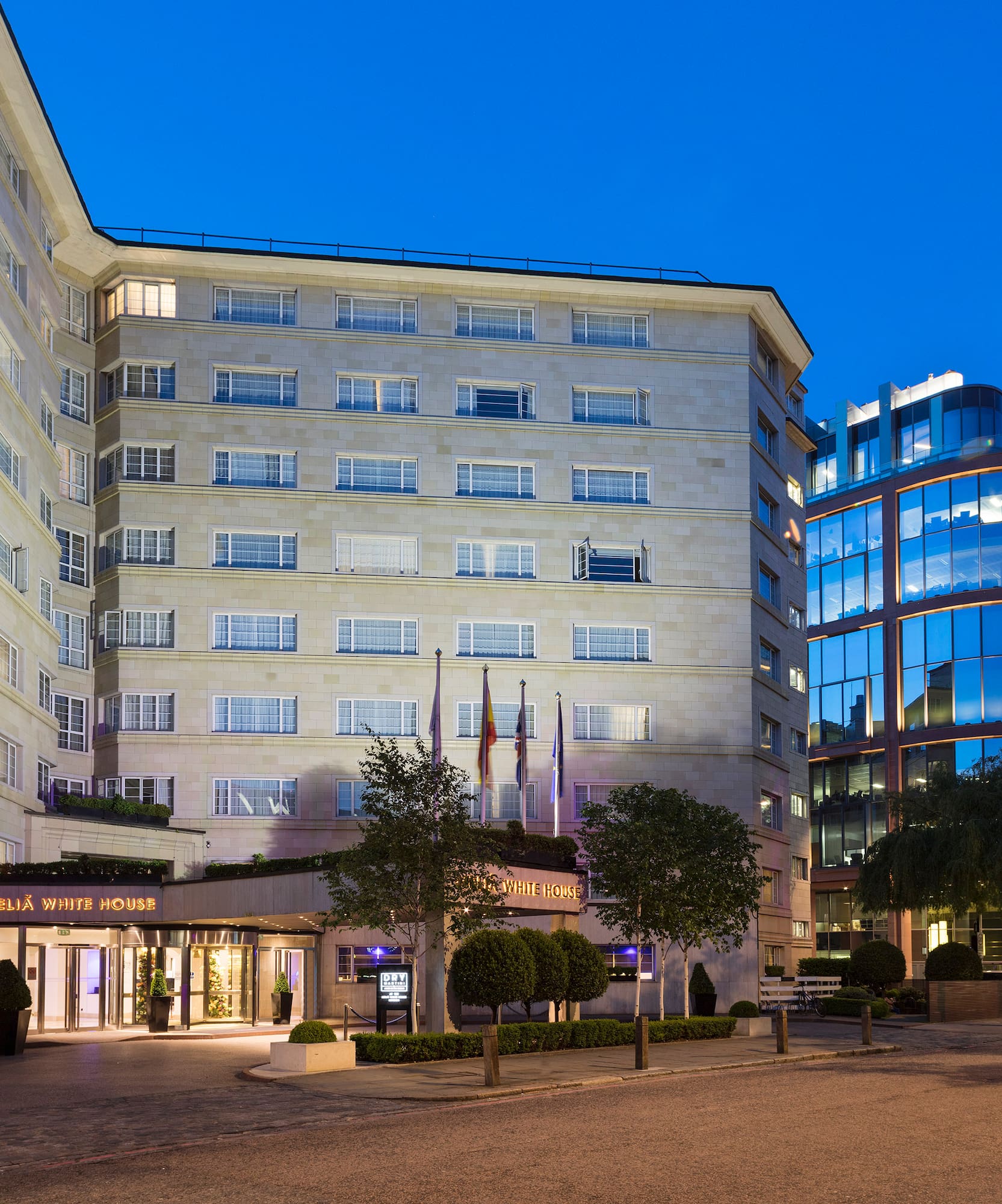 a building with many windows and a street with trees and a road