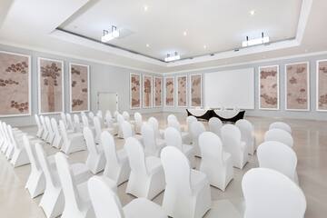 a room with white chairs and a table