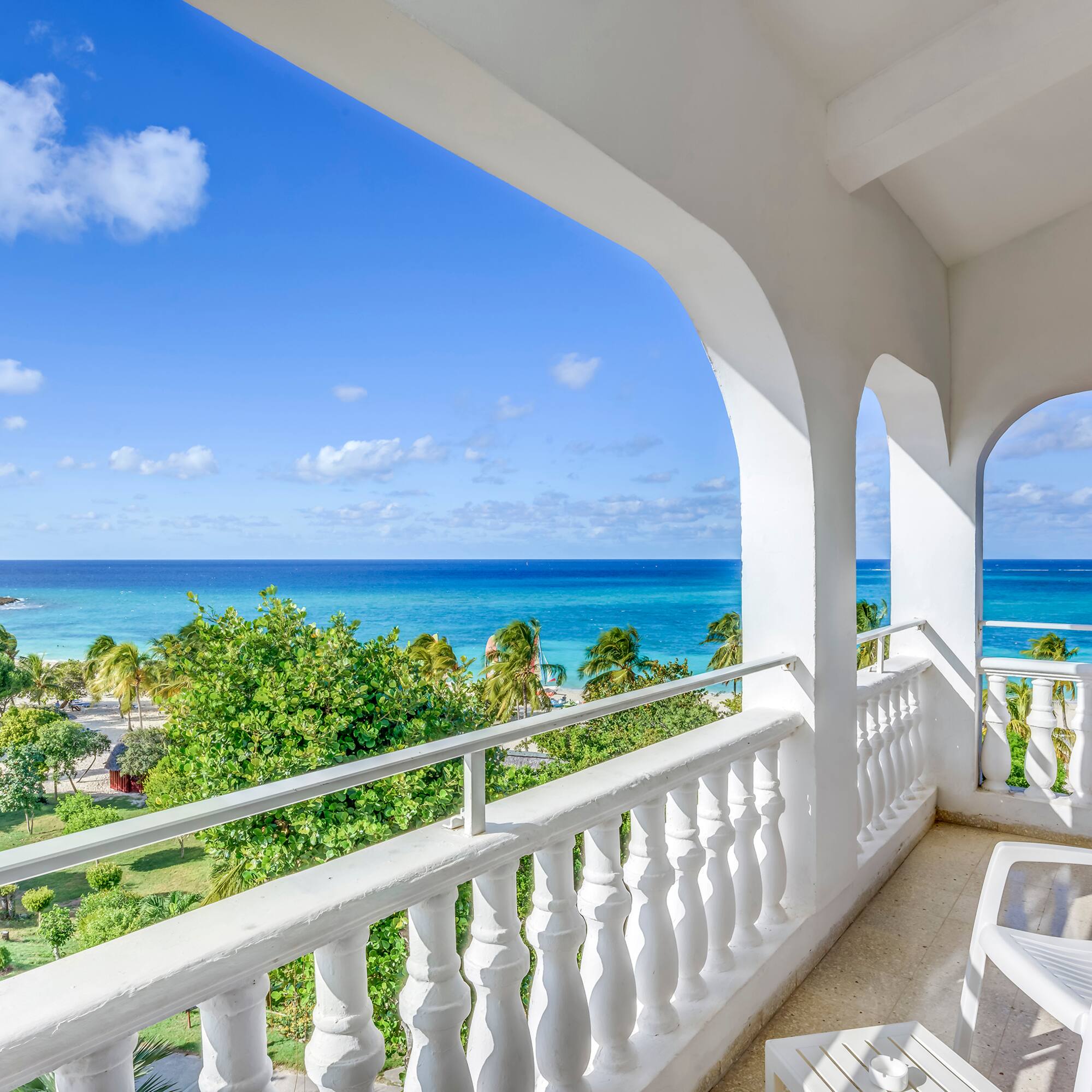 a balcony with a view of the ocean and trees