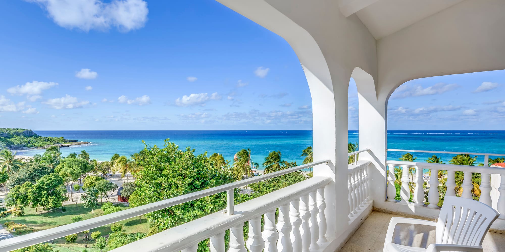 a balcony with a view of the ocean and trees