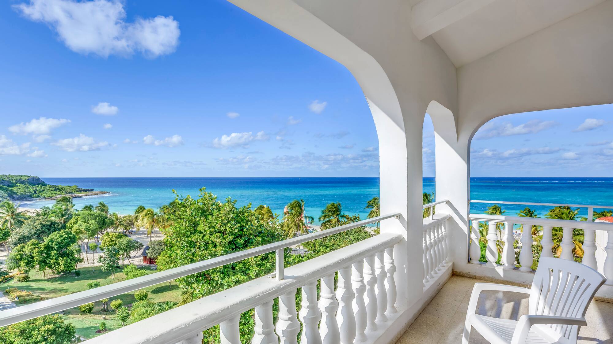 a balcony with a view of the ocean and trees