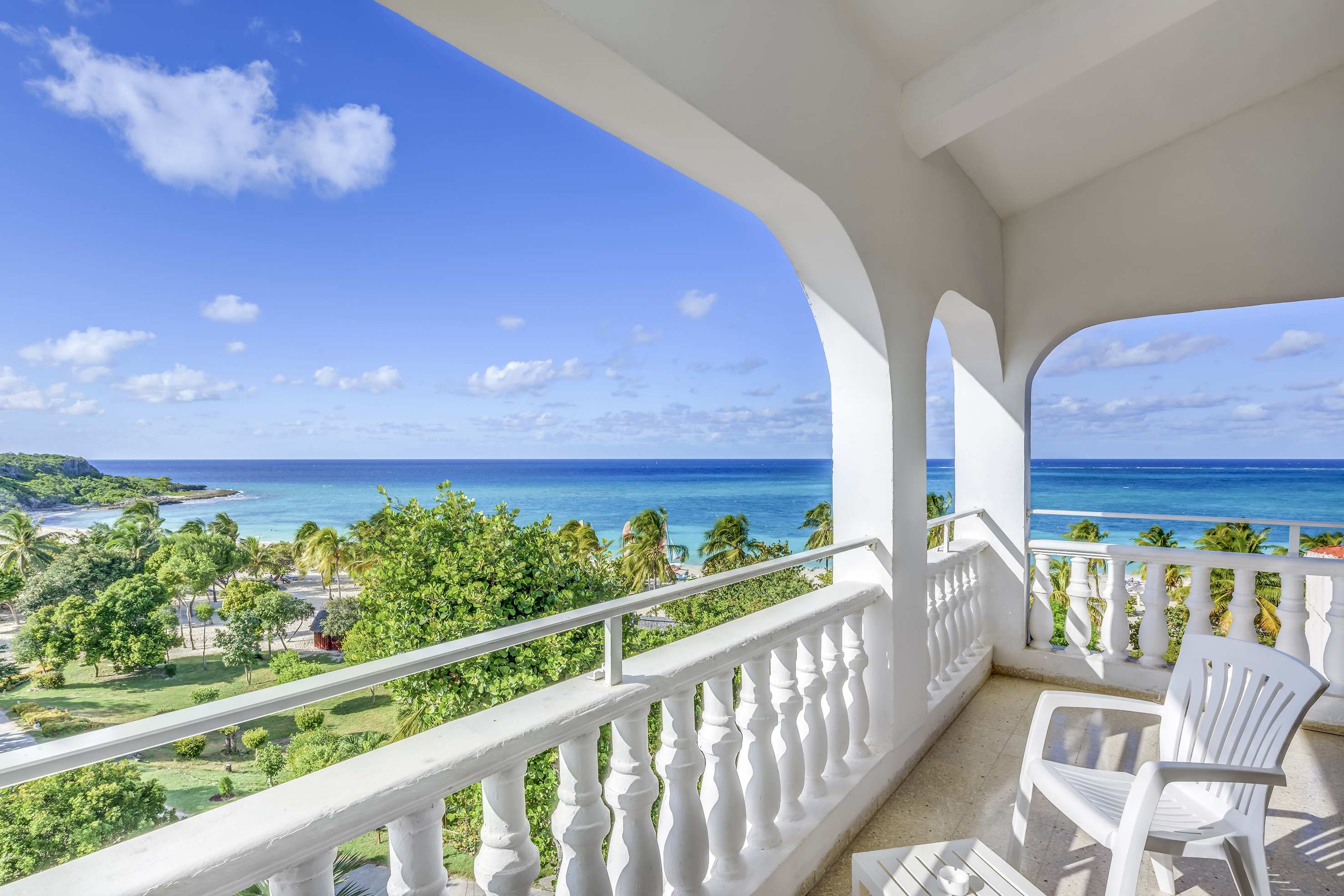 a balcony with a view of the ocean and trees