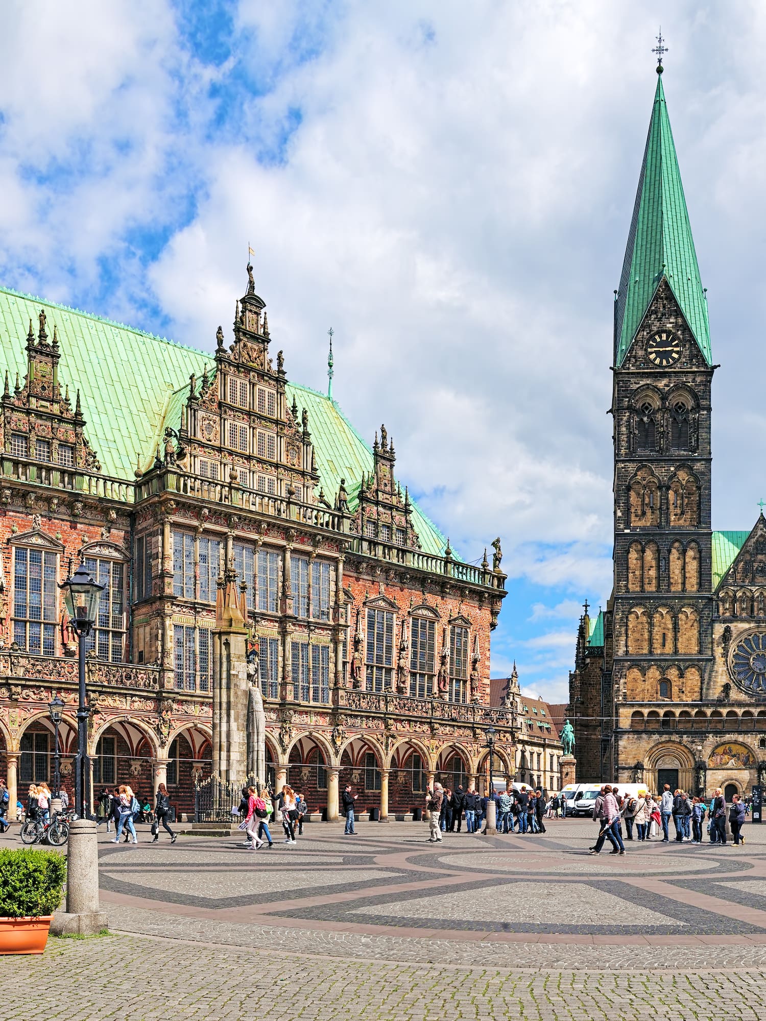 a large building with towers and people walking around