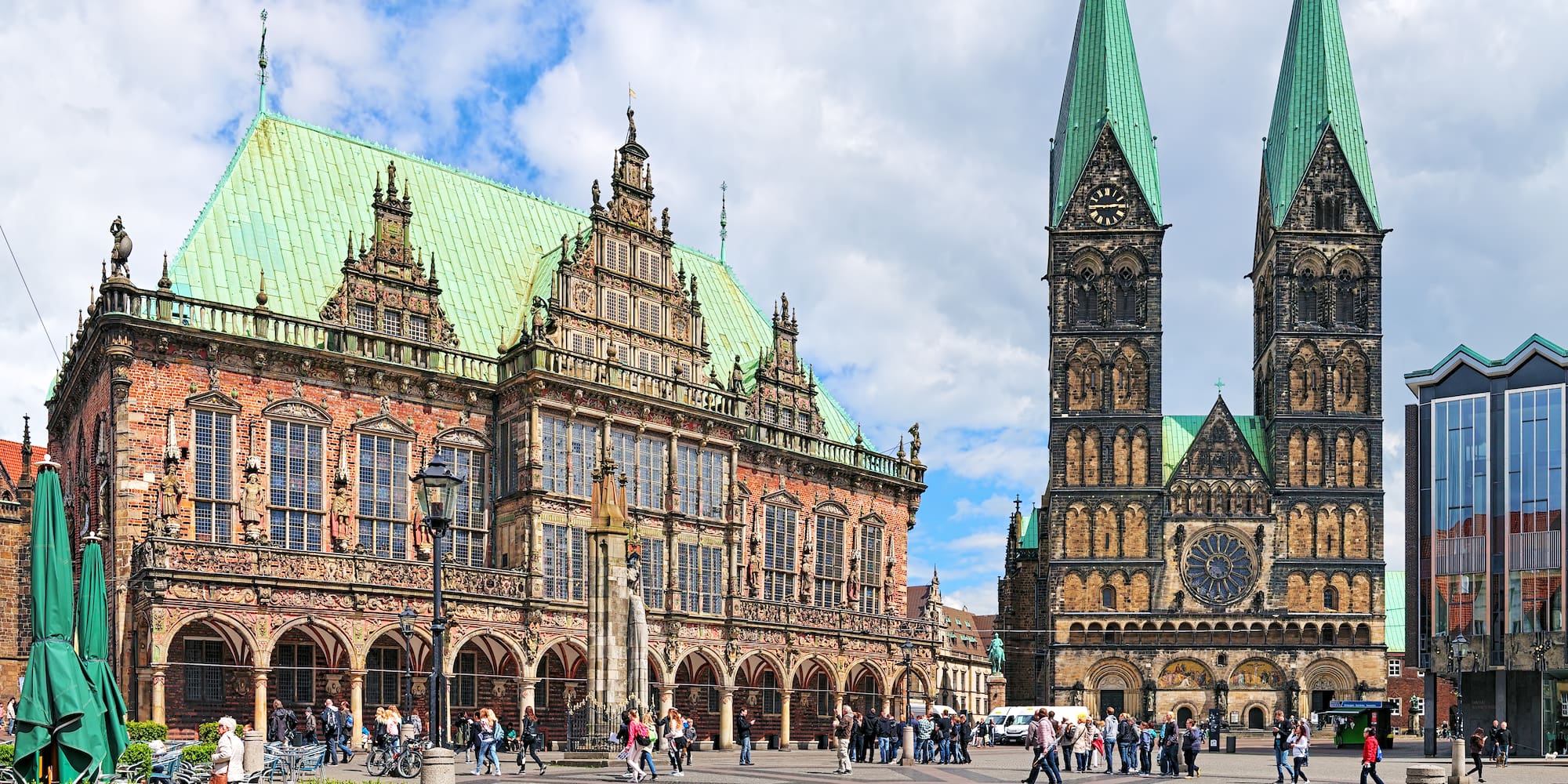 a large building with towers and people walking around