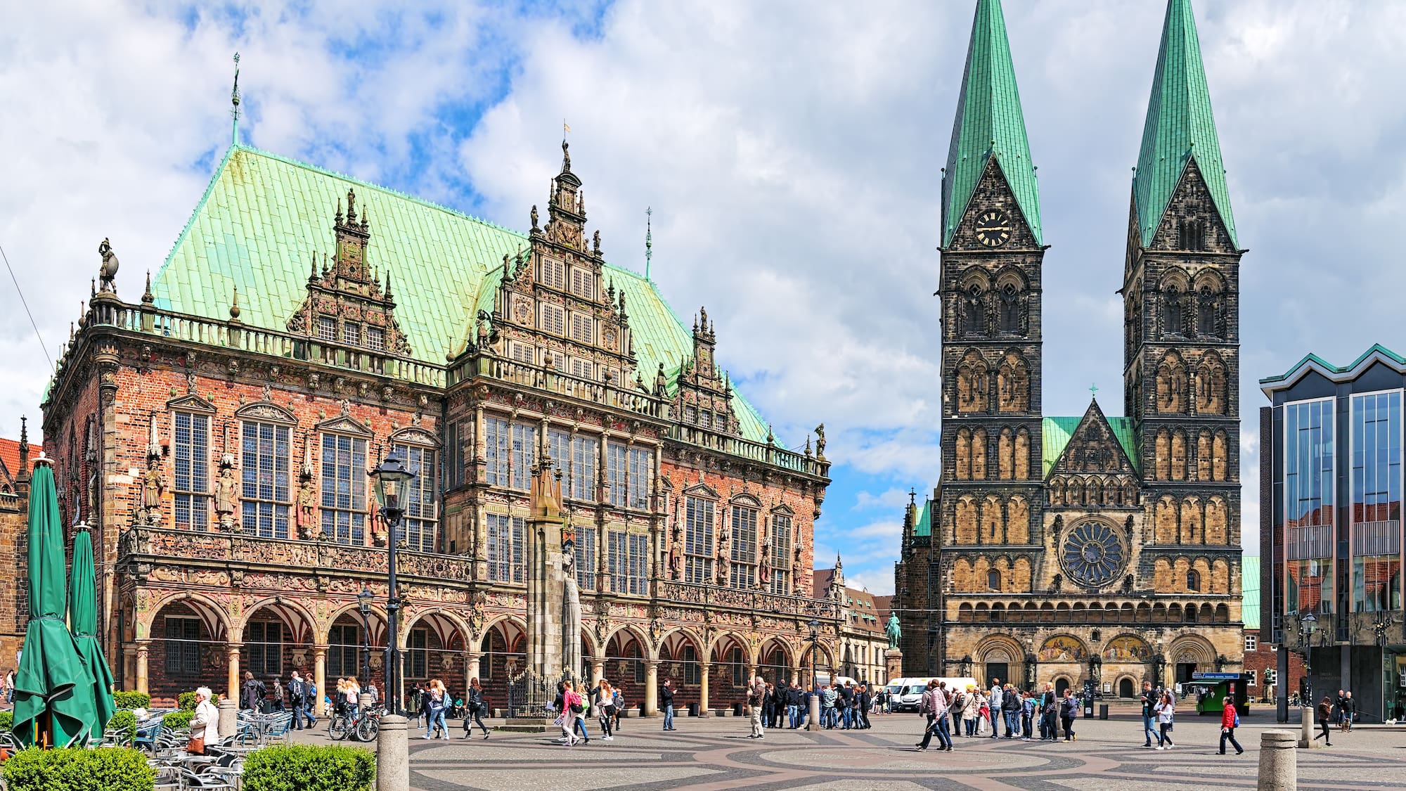 a large building with towers and people walking around