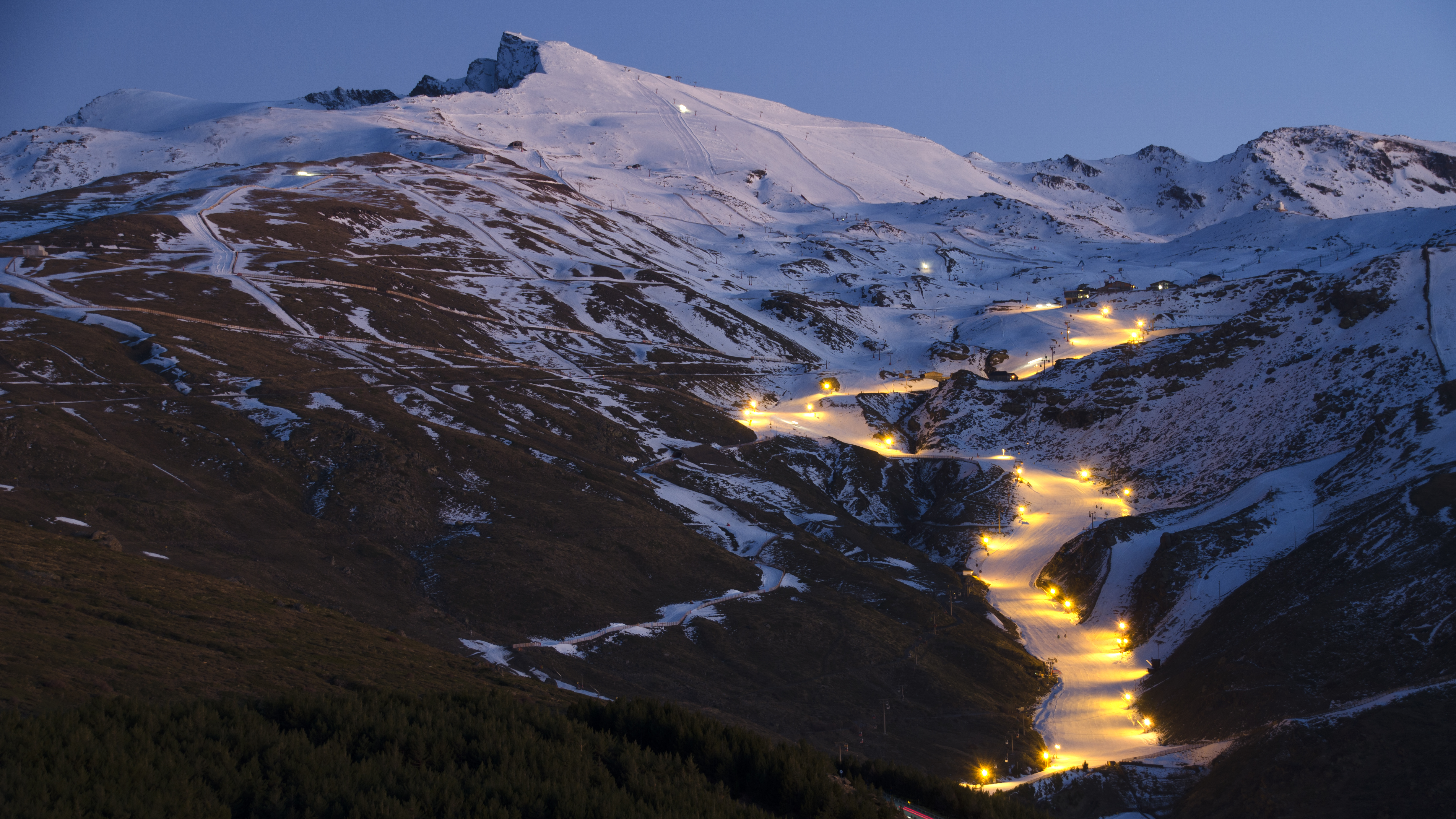 a snowy mountain with lights on it