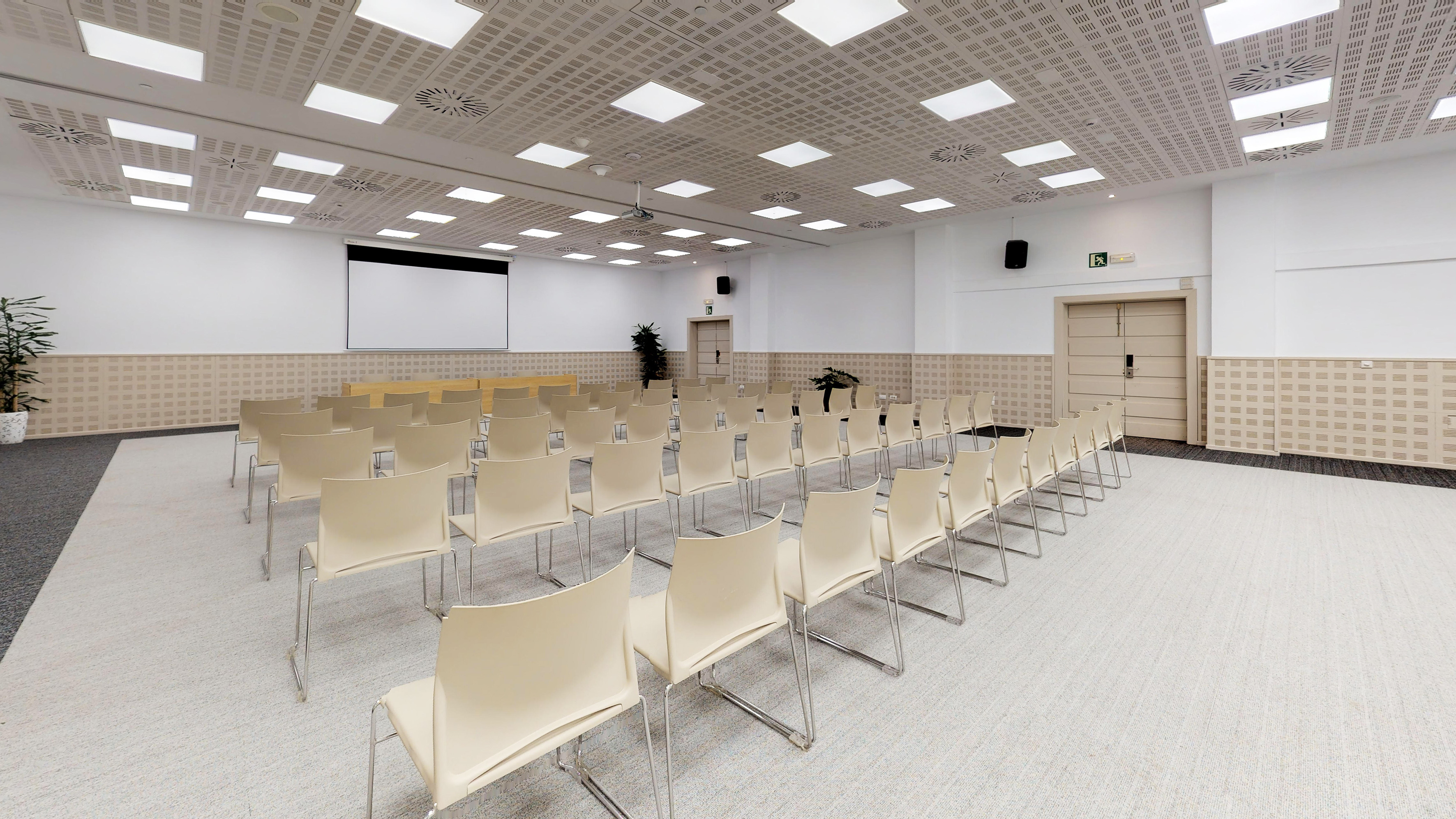 Spacious conference room with beige chairs, projector screen, ready for events.