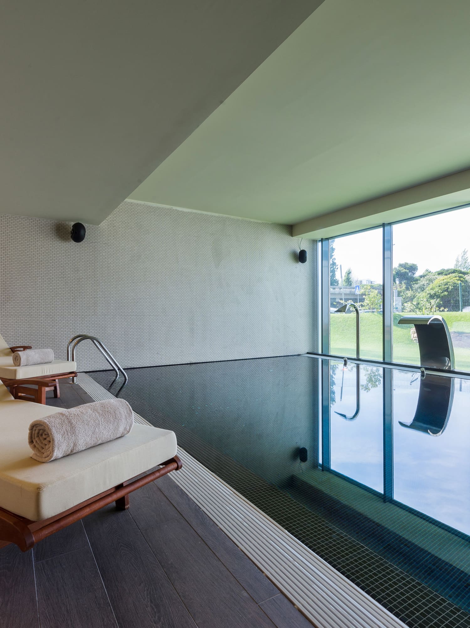 a pool with chairs and a large window