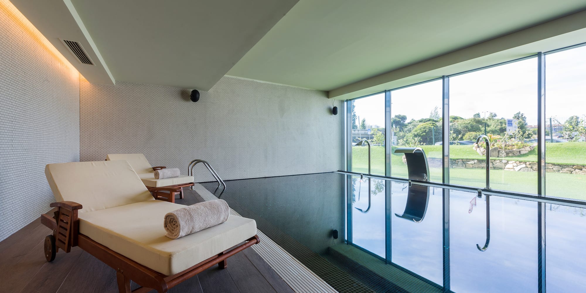 a pool with chairs and a large window