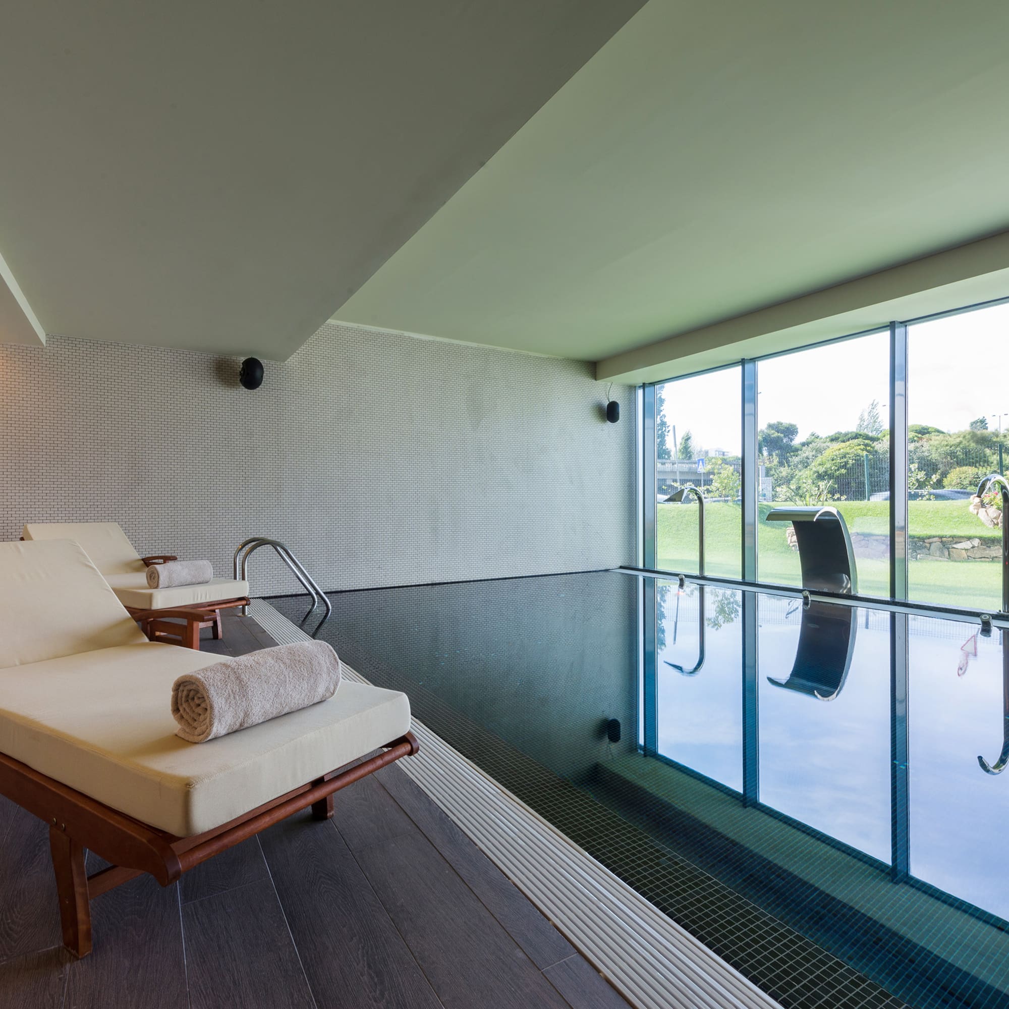 a pool with chairs and a large window