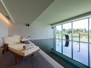 a pool with chairs and a large window