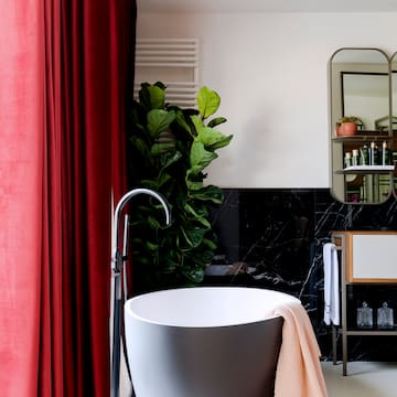 a bathroom with a tub and a red curtain