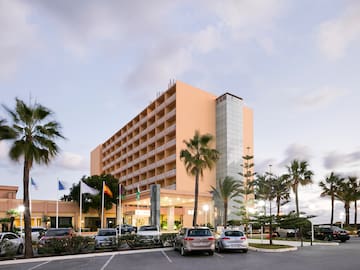 a building with palm trees and flags