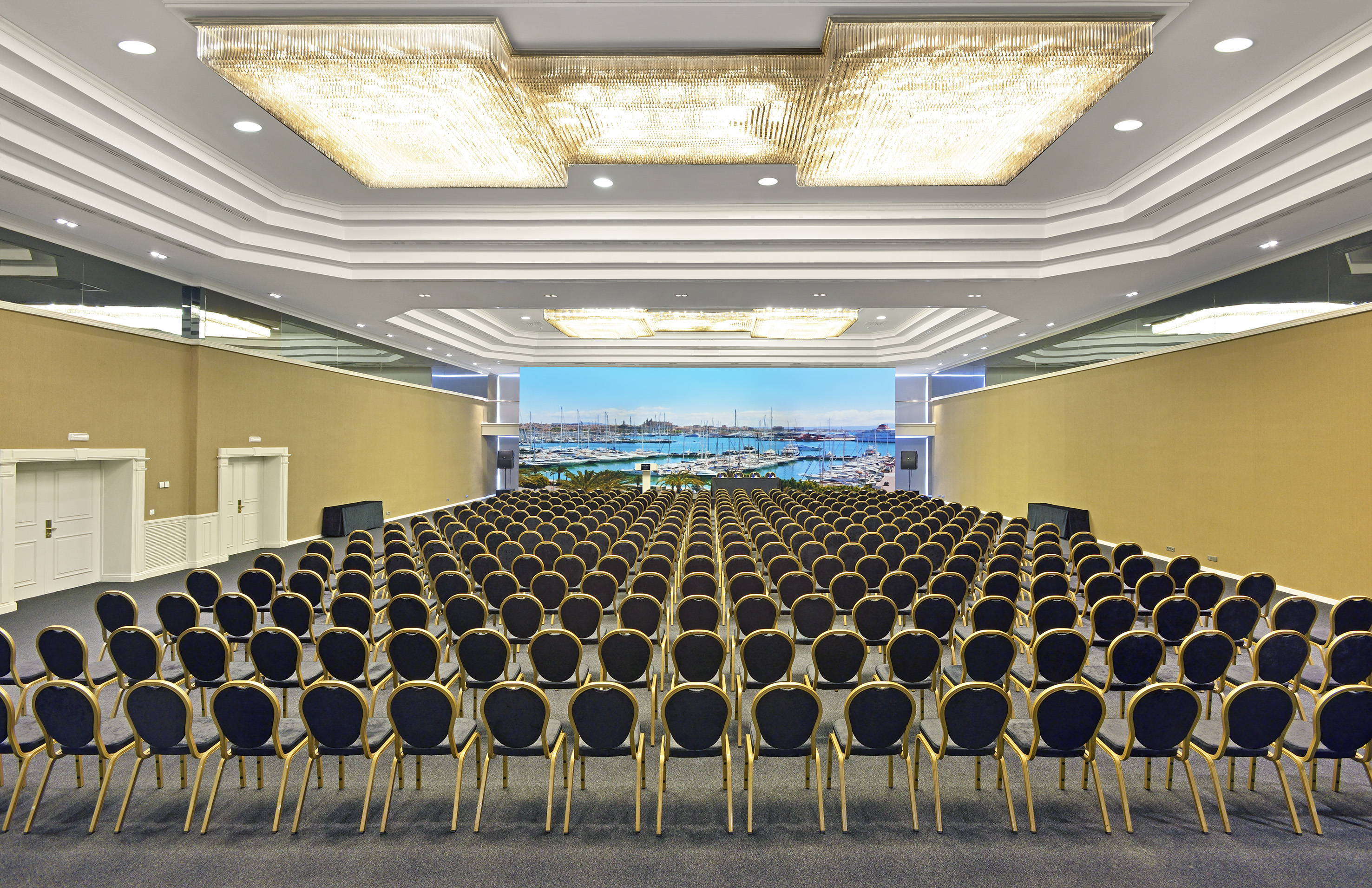 Conference ballroom, theater seating, marina screen view, luxury chandeliers.