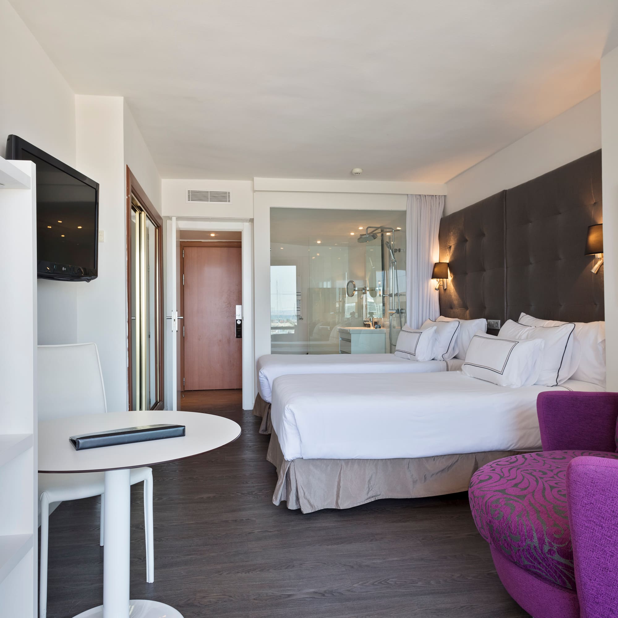 a room with two beds and a purple chair