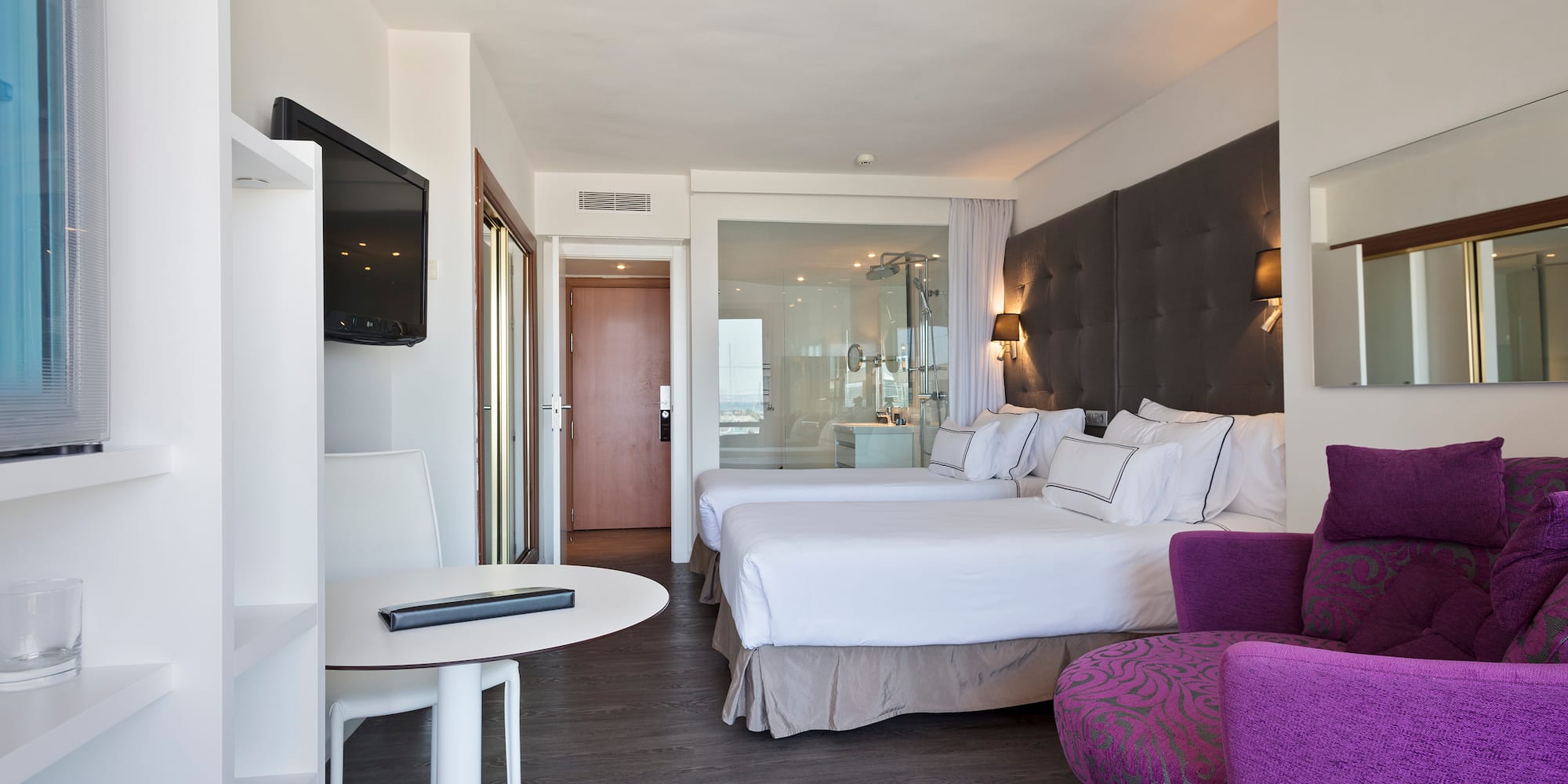 a room with two beds and a purple chair