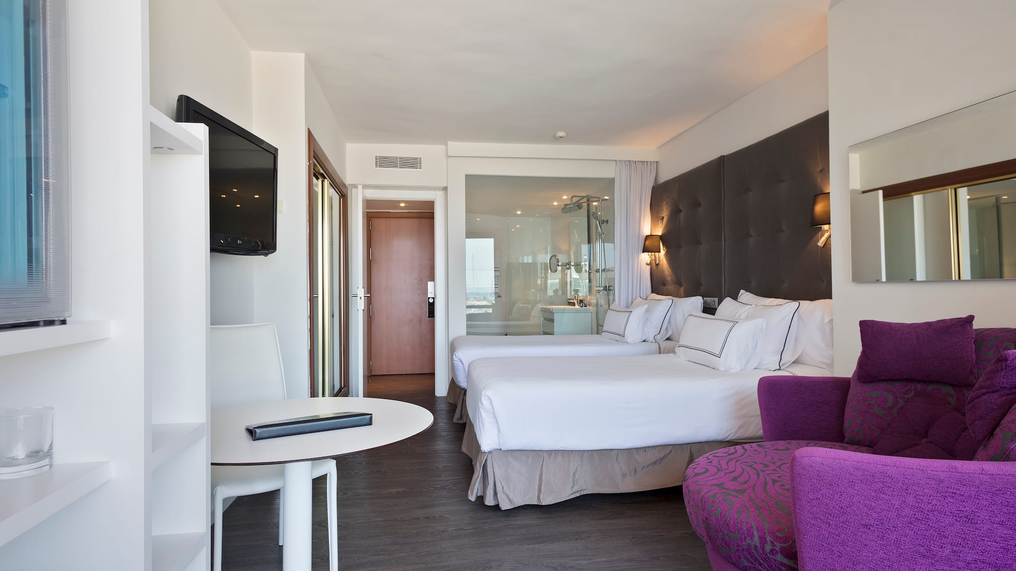 a room with two beds and a purple chair