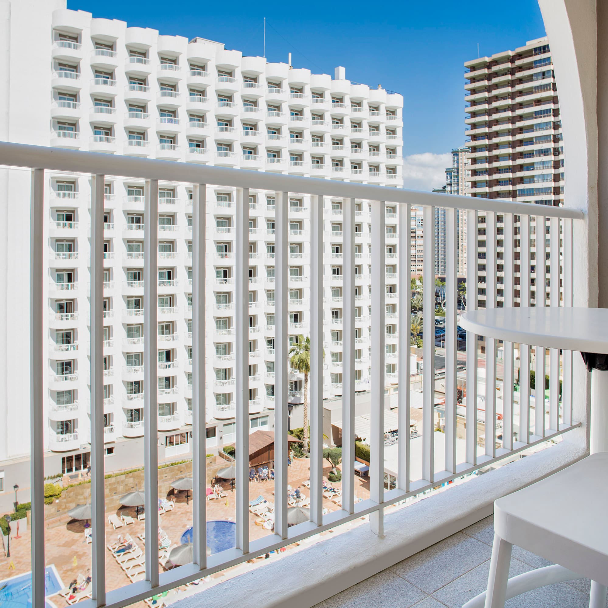 a balcony with a table and chairs and a white railing