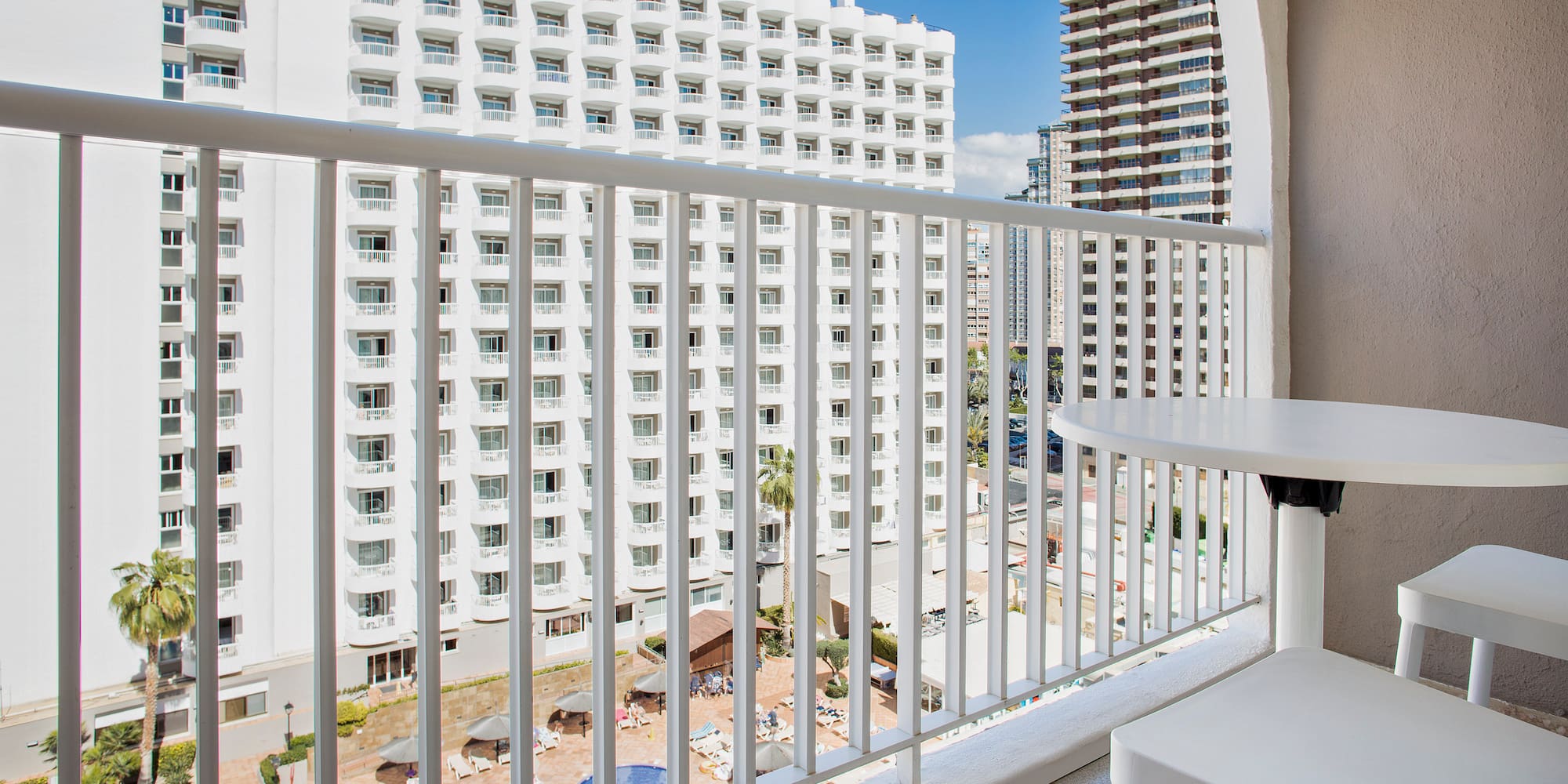 a balcony with a table and chairs and a white railing