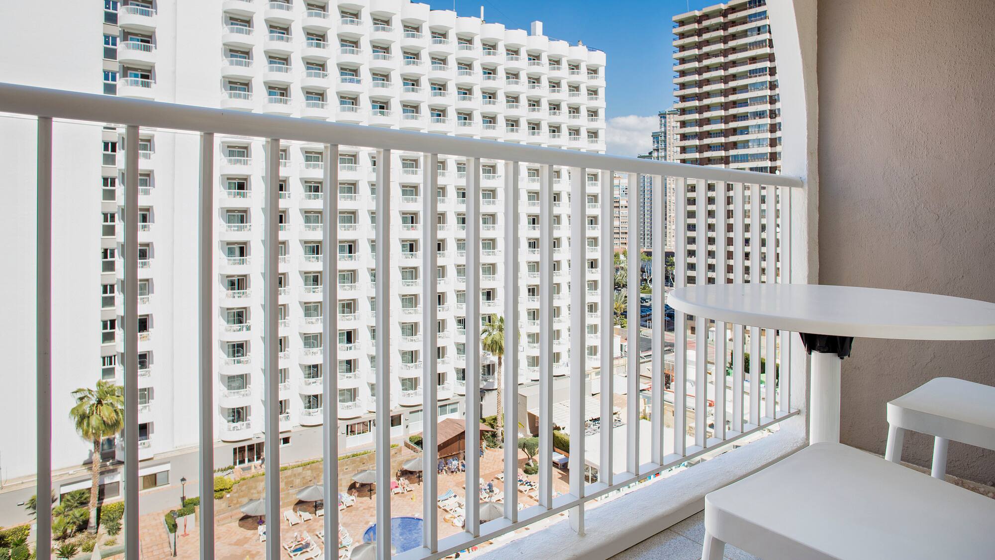 a balcony with a table and chairs and a white railing