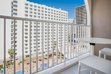 a balcony with a table and chairs and a white railing