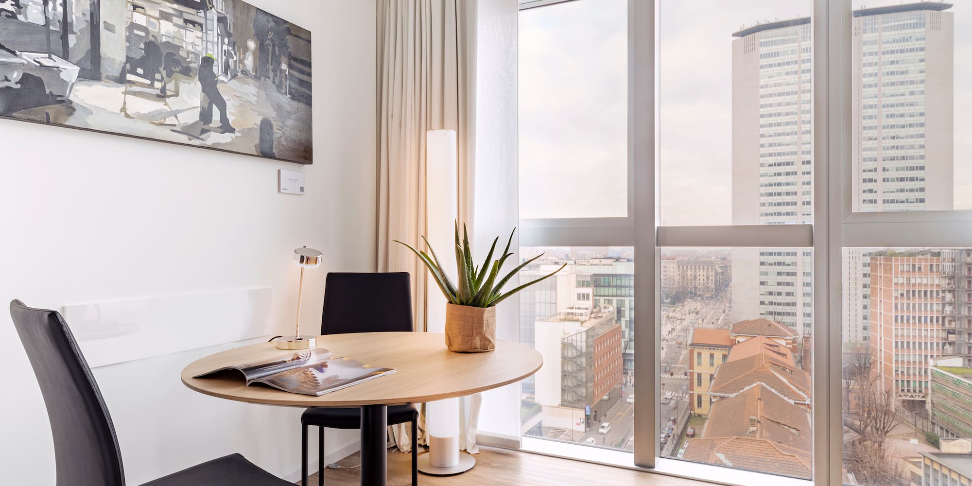 a room with a table and chairs and a plant