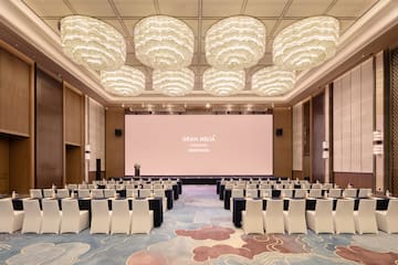 a room with a large screen and chairs