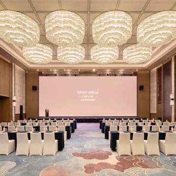 a room with a large screen and chairs