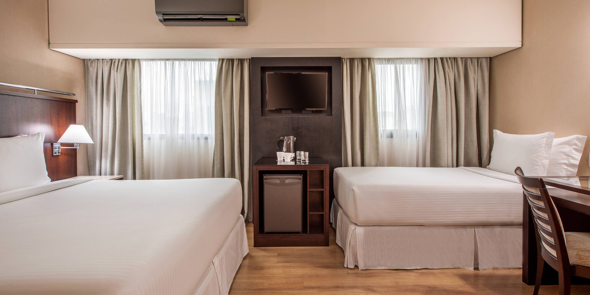 a room with two beds and a television